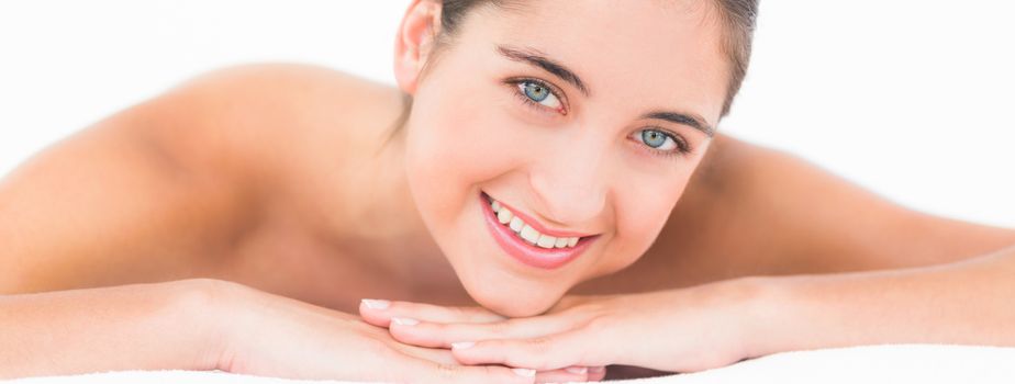 Portrait smiling pretty brunette on massage table with white backgroung 