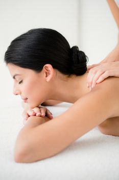 Pretty brunette enjoying a massage at the health spa