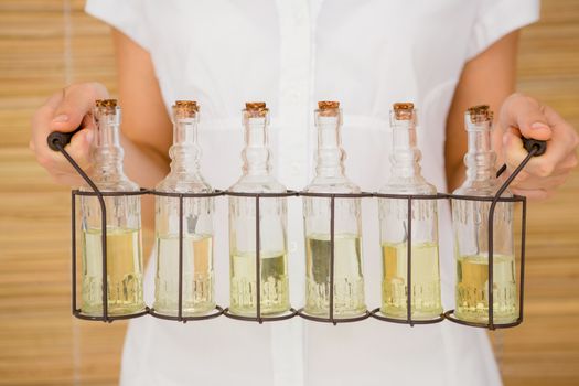 Close up view of woman holding bottles of oil massage