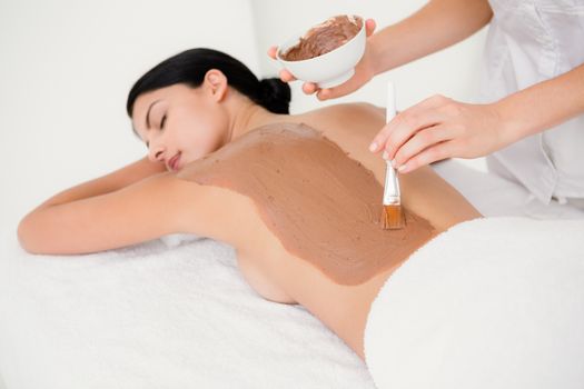 Beautiful brunette enjoying a chocolate beauty treatment at the health spa