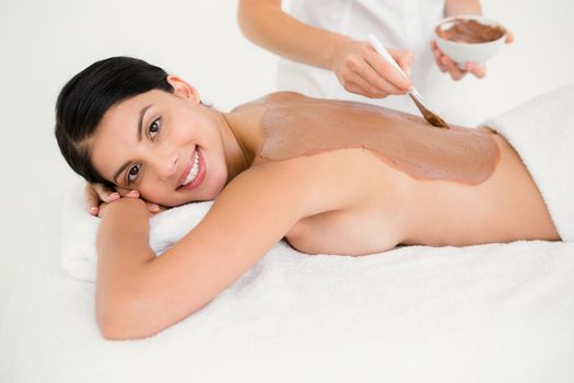 Beautiful brunette enjoying a chocolate beauty treatment at the health spa