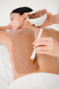 Beautiful brunette enjoying a chocolate beauty treatment at the health spa