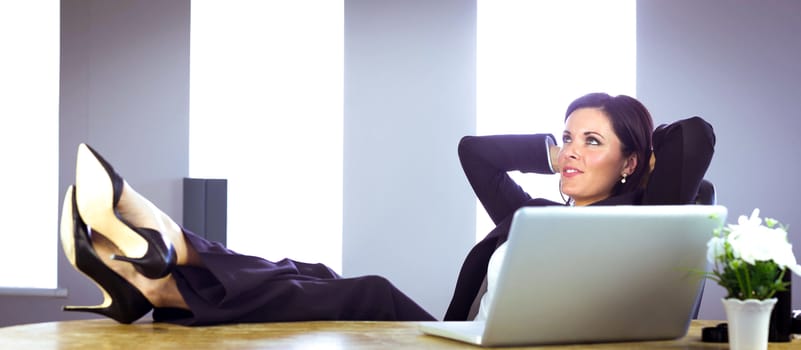 Businesswoman relaxing at her desk in her office