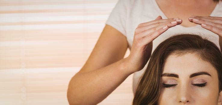 Young woman having a reiki treatment in therapy room