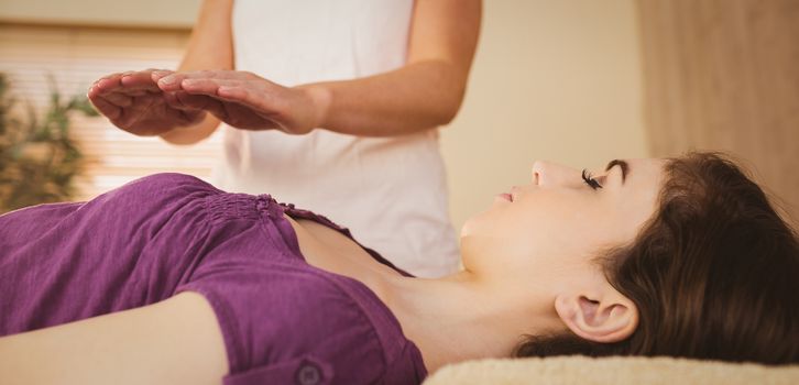 Young woman having a reiki treatment in therapy room