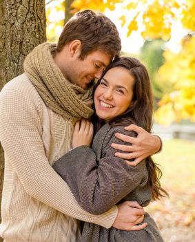 love, relationship, family and people concept - smiling couple hugging in autumn park