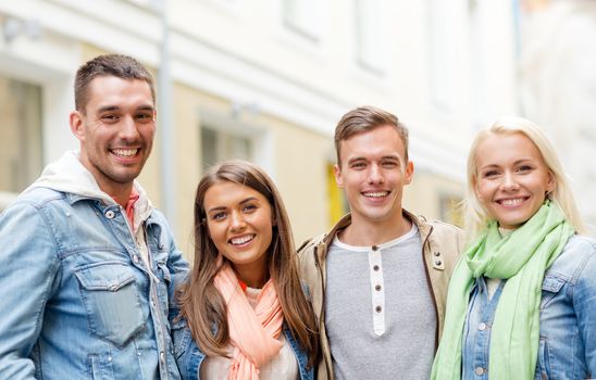 travel, vacation and friendship concept - group of smiling friends in city