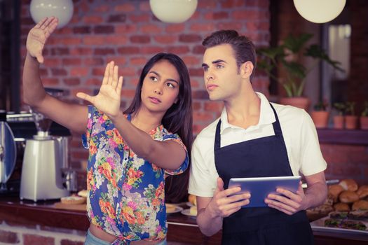 Pretty customer explaining to waiter at coffee shop