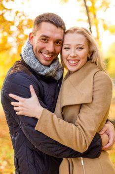 love, relationship, family and people concept - smiling couple hugging in autumn park