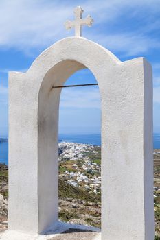 Arch with cross in the landscape of Santorini, Greece