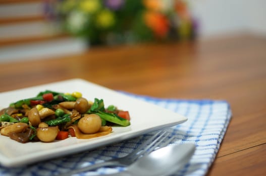 Vegetarian fried noodle with soy sauce in white plate on table.                               