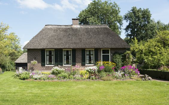 GIETHOORN, NETHERLANDS - JULY 18, 2015: view of typical houses of Giethoorn on July 18, 2015  in Giethoorn,The Netherlands. Giethoorn is also called 'the Venice of Holland' and receives 15.000 visitors yearly.