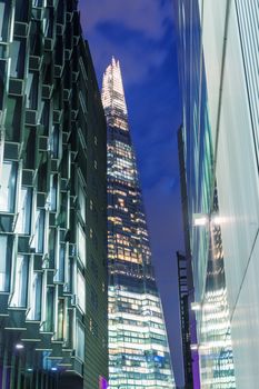 LONDON - JUNE 12, 2015: The Shard at night framed by buildings. The Shard, standing 309m, is the tallest building in Europe