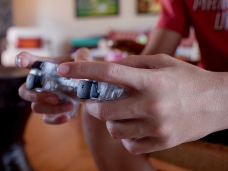 Video game console controller in gamer hands. The kid play computer games online.