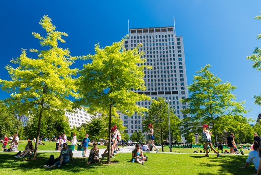 LONDON - JUNE 16, 2015: Tourists relax on Jubilee Gardens. The city attracts 50 million people annually.