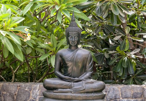 Metal buddha statue lotus pose in the garden.