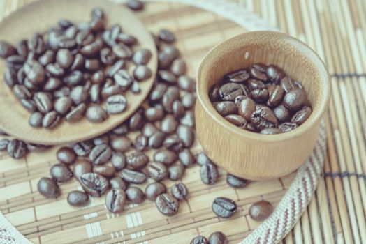 Coffee beans and coffee cup set on bamboo wooden background.Photo in retro color image style, Soft focus.