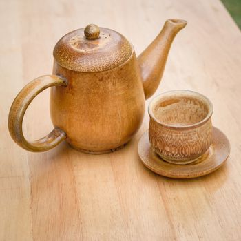 Cup of tea and teapot on wooden desk