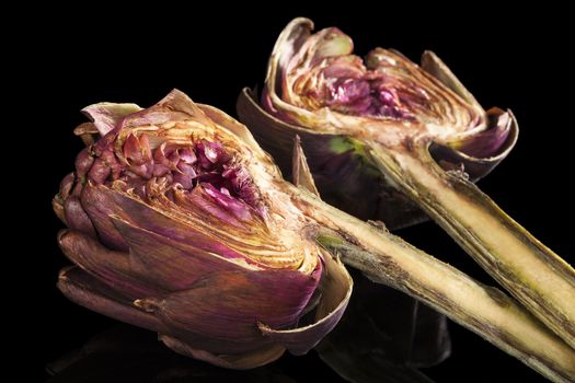 Fresh artichoke isolated on black background. Culinary healthy vegetable eating. 