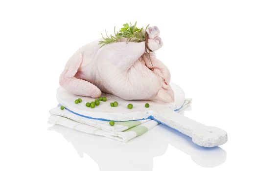 Raw organic whole chicken with herbs on cutting board isolated on white, prepared for baking. Culinary cooking.
