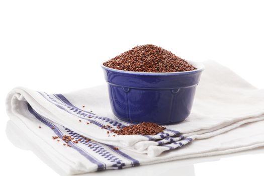 Red quinoa seeds in bowl isolated on white background. Healthy eating.