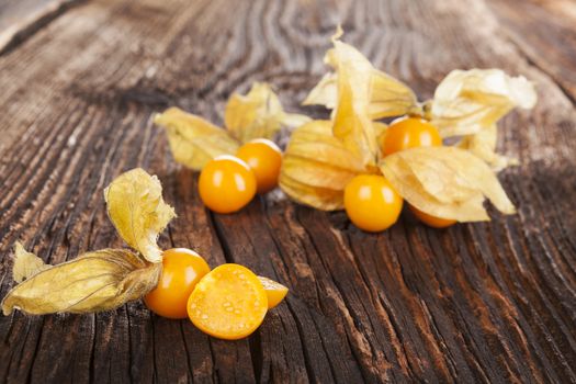 Physalis, groundcherriesl on brown textured aged background. Tropical healthy fruit eating.