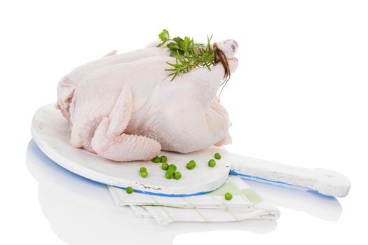 Raw organic whole chicken with herbs on cutting board isolated on white, prepared for baking. Culinary cooking.