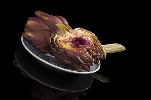 Fresh artichoke isolated on black background. Culinary healthy vegetable eating. 