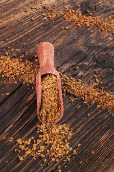 Instant coffee on wooden scoop on old wooden background. Culinary coffee background. 