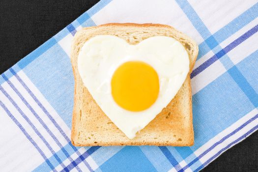 Sunny side up egg in heart shape on toast, top view. I love breakfast. Fresh modern image language. Culinary arts. 
