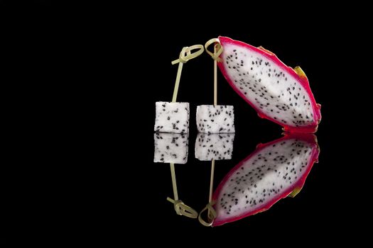 Dragon fruit isolated on black background. Tropical fruit salad.