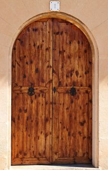 Oval wooden doors with ancient iron knocker and locker