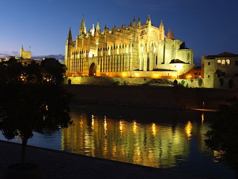 Cathedral of la Seu Mallorca at Palma de Mallorca, Balearic islands in Spain. Night scene with reflection over fountain.