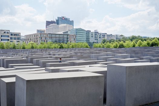 BERLIN, GERMANY - JULY 08: Lone man walking among stone blocks at the Memorial to the Murdered Jews of Europe. July 08, 2015 in Berlin.
