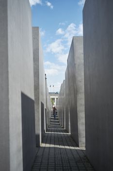BERLIN, GERMANY - JULY 08: Tourists walking among stone blocks at the Memorial to the Murdered Jews of Europe. July 08, 2015 in Berlin.