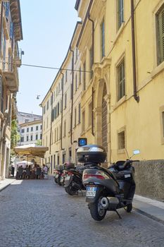 VERONA, ITALY - JULY 11: Low angle shot of stone street with scooters parked. July 11, 2015 in Verona.