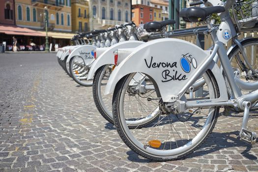 VERONA, ITALY - JULY 11: Low angle cropped shot the city's cycle hire bicycles parked in line. July 11, 2015 in Verona.