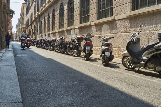 VERONA, ITALY - JULY 13: Low angle shot of street with scooters parked. July 13, 2015 in Verona.