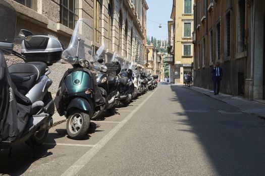 VERONA, ITALY - JULY 13: Low angle shot of street with scooters parked. July 13, 2015 in Verona.