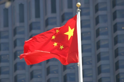 Chinese flag with flag pole waving in the wind 
