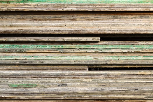 timber planks layered on top of each other with green paint splotches.