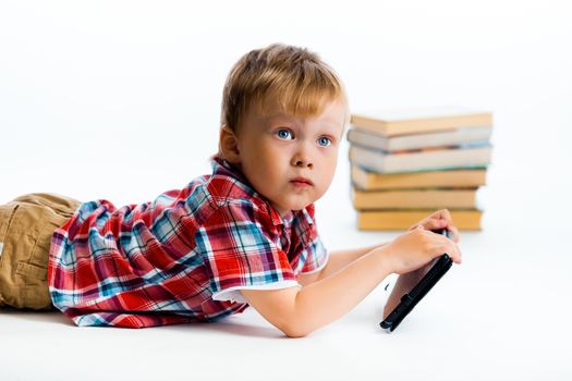 A small boy with tablet computer and books