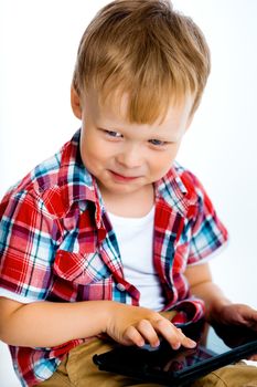 Little smiling boy with a tablet computer