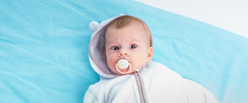 Baby in the hood on a blue blanket