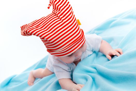 beautiful baby in the cap on a blue blanket