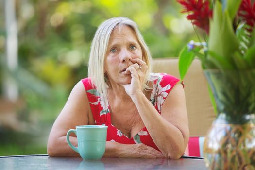 Serious Caucasian adult biting fingernails with worried expression 