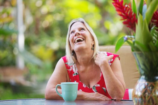 Attractive single mature woman at table laughing