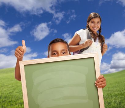 Hispanic Students with Thumbs Up in Grass Field Holding Blank Chalk Board.