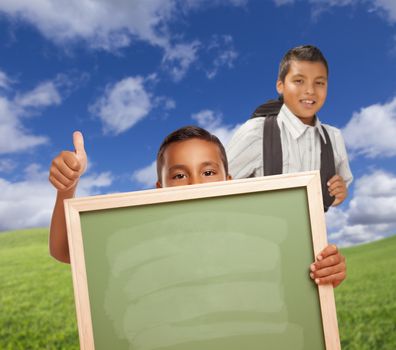 Hispanic Students with Thumbs Up in Grass Field Holding Blank Chalk Board.