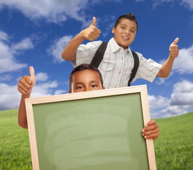 Hispanic Students with Thumbs Up in Grass Field Holding Blank Chalk Board.